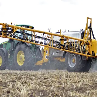 tractor applying agricultural herbicides in a field