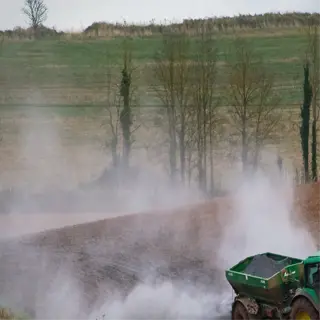 tractor spreading organic fertilizer in a field
