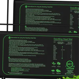 two seedling heat mats with instructions and a tray of seedlings