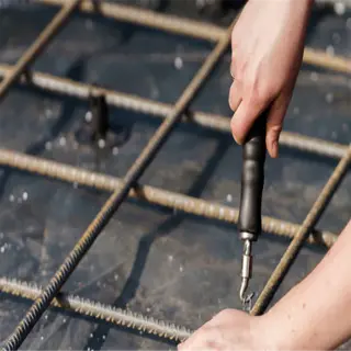 worker tying square foot rebar grid for concrete slab