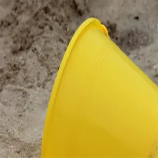 yellow plastic bucket on the ground, likely for soil sampling